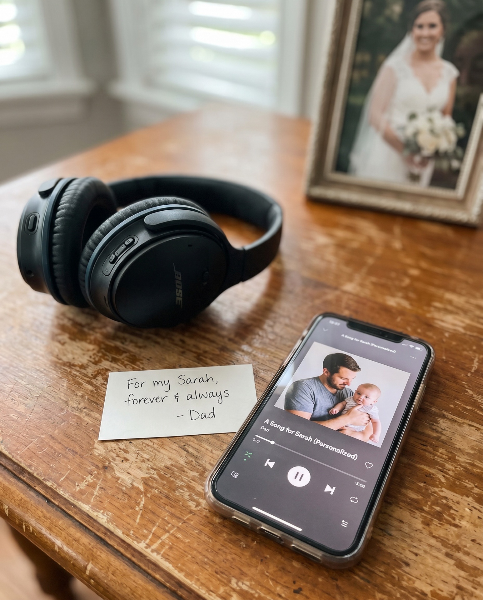 Headphones, a handwritten note 'For my Sarah, forever & always — Dad', and a phone playing 'A Song for Sarah'